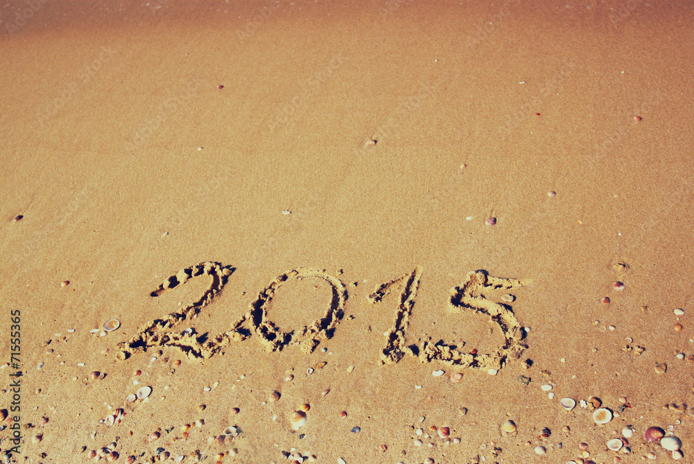 Fototapeta premium New year 2015 written on sandy beach. retro filtered image