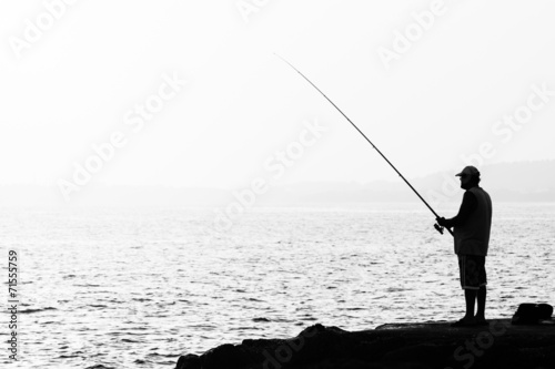 Evening fishing. Lone fisherman fishing from the shore. © Sergey Kohl