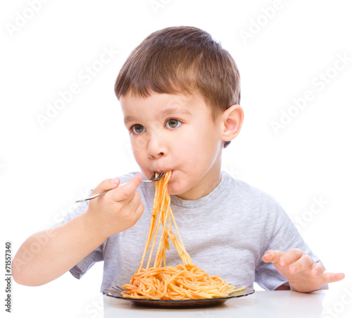 Little boy is eating spaghetti