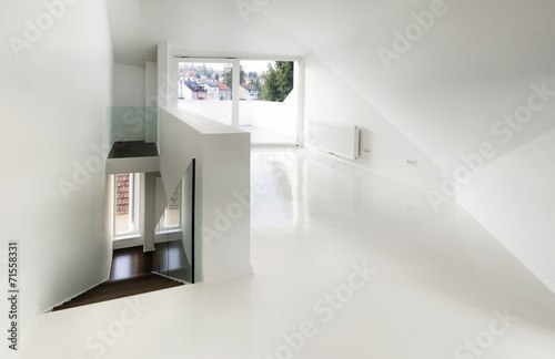 Empty attic room with white epoxy flooring