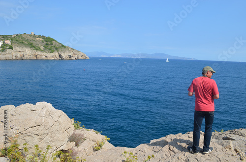 man climbing on rock coast