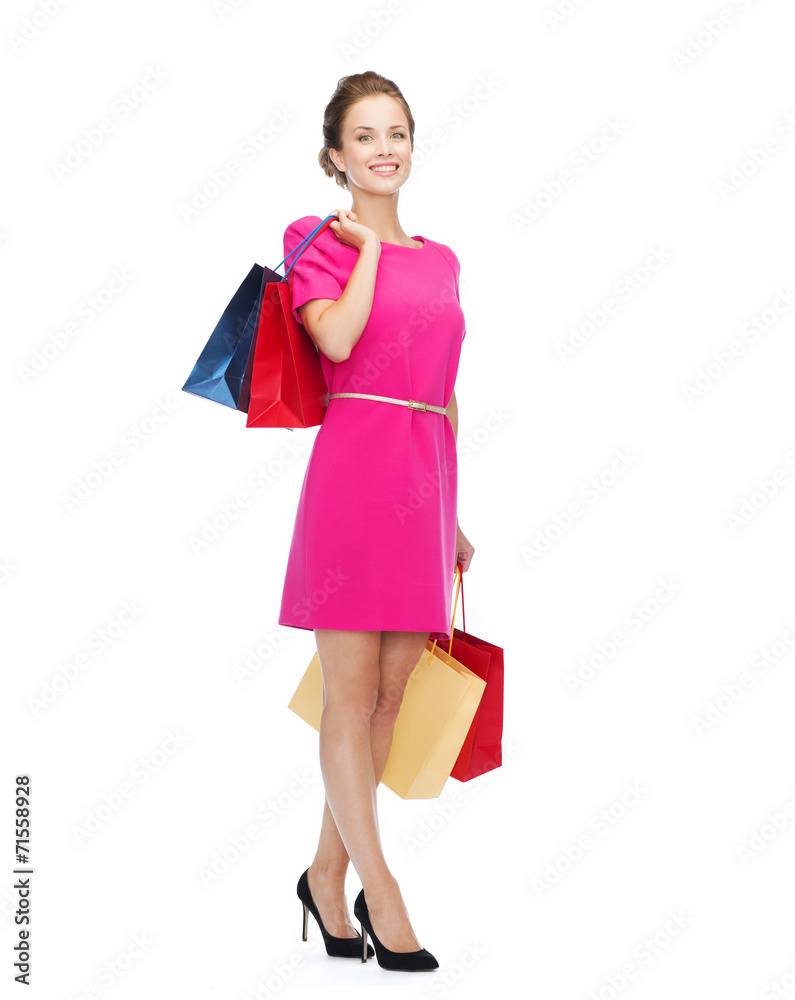smiling woman in pink dress with shopping bags