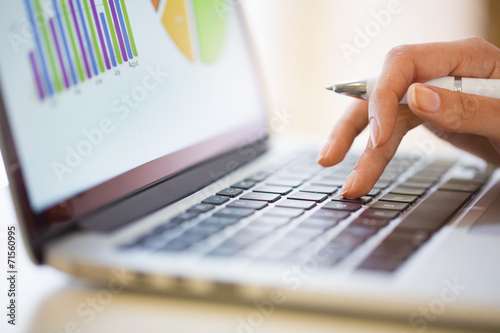 Woman working on financial data with computer