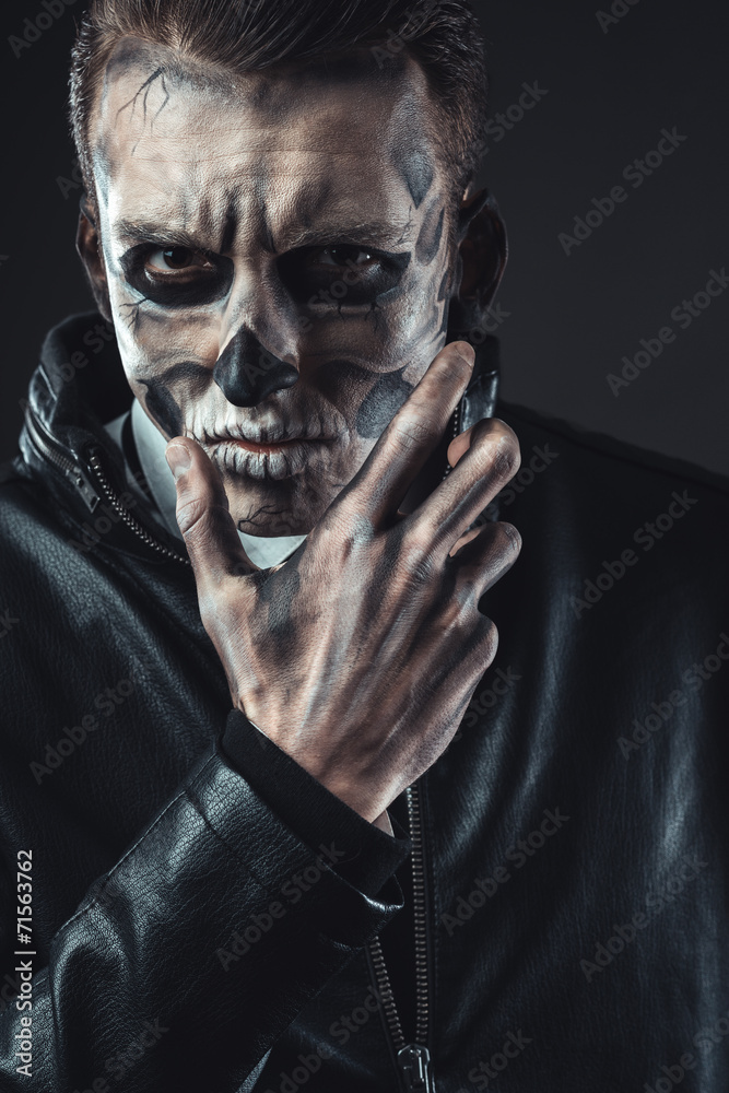 Portrait of pensive man with make-up  skull