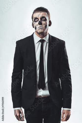 Sad businessman with makeup skeleton