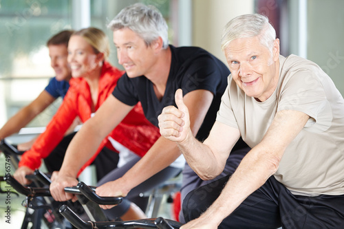 Senior im Fitnesscenter hält Daumen hoch