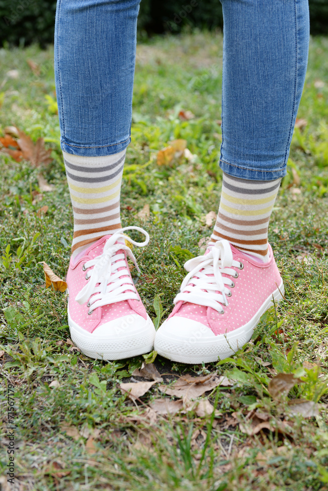 Female legs in colorful socks and sneakers outdoors