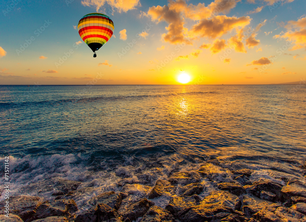 Naklejka premium Hot air balloon over the sea at sunset