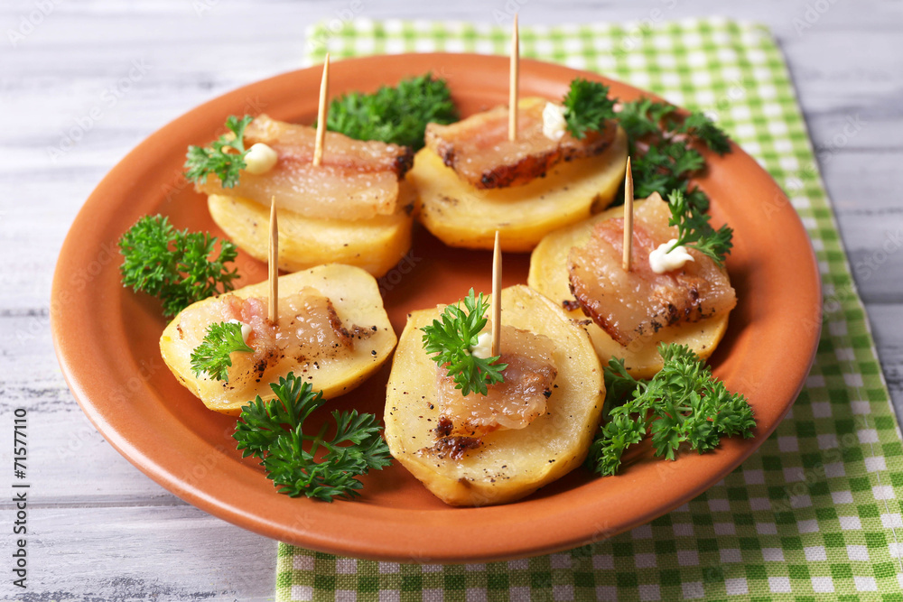 Baked potato with bacon on plate, on wooden background Baked potato with bacon on plate, on wooden background