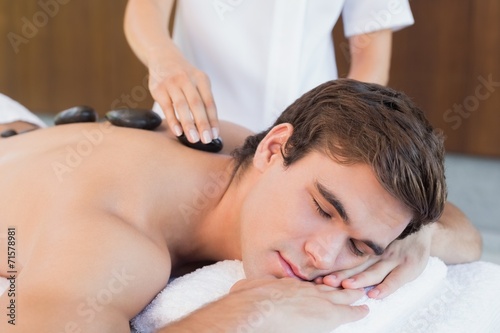 Young man receiving stone massage at spa center © WavebreakmediaMicro