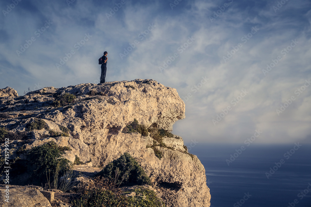 Man on a rock admiring the horizon