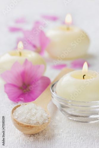 spa composition with sea salt  pink flowers and burning candles