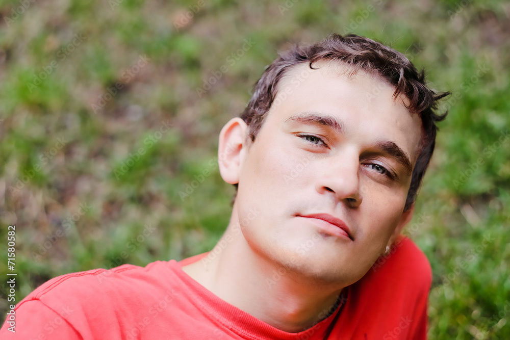 pensive young man relaxing in a park pensive young man relaxing in a park