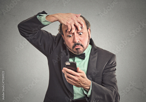 sleepy man trying to stay awake holding smart phone