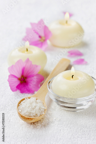 spa composition with sea salt  pink flowers and burning candles