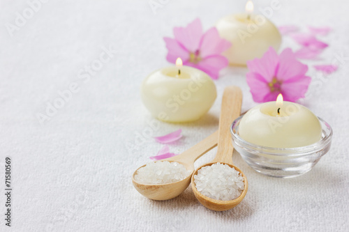 spa composition with sea salt  pink flowers and burning candles