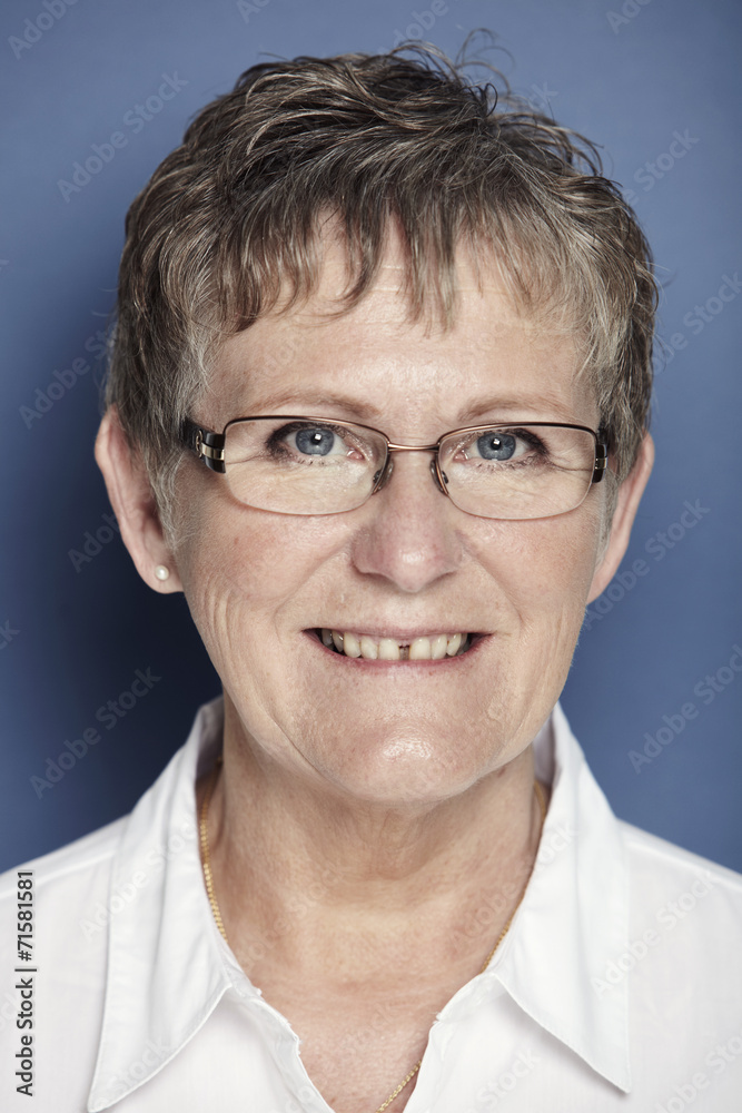 Portrait of senior woman smiling against blue background