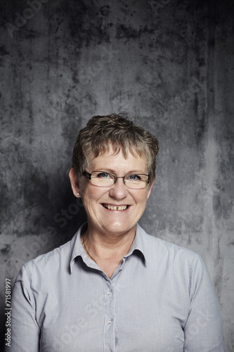 Portrait of smiling senior woman in grey, close up