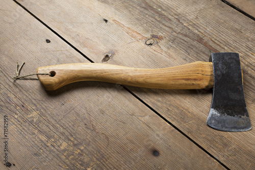 Wooden handle axe lying on wooden table