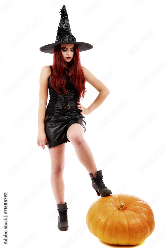portrait of a charming red-haired witch holding pumpkin . Hallow portrait of a charming red-haired witch holding pumpkin . Hallow