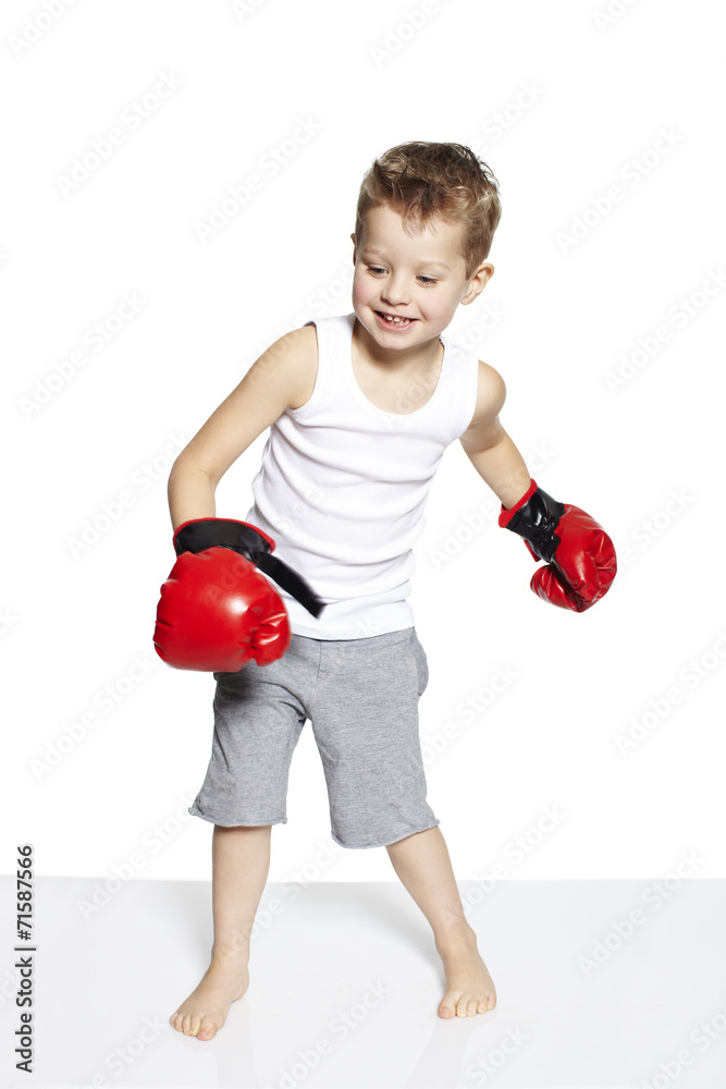 Young boy in boxing gloves smiling in studio Young boy in boxing gloves smiling in studio