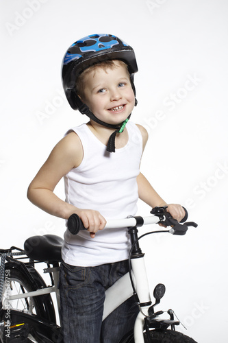 Portrait of young boy on bicycle, studio
