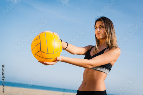 Photography Beautiful beach volleyball female player serving ball.