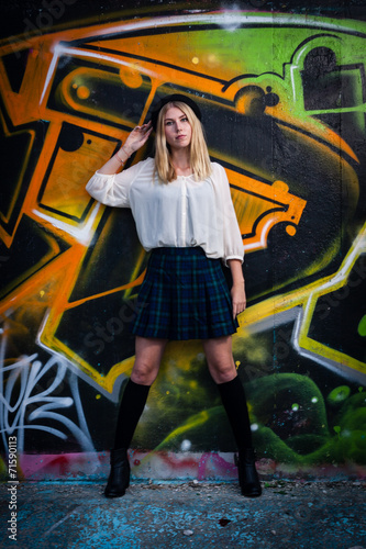 Blonde girl in front of graffiti
