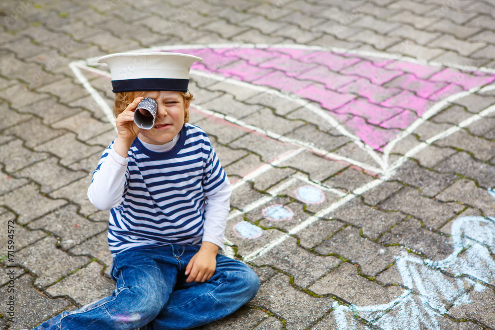 Little boy having fun with ship picture drawing with chalk Little boy having fun with ship picture drawing with chalk