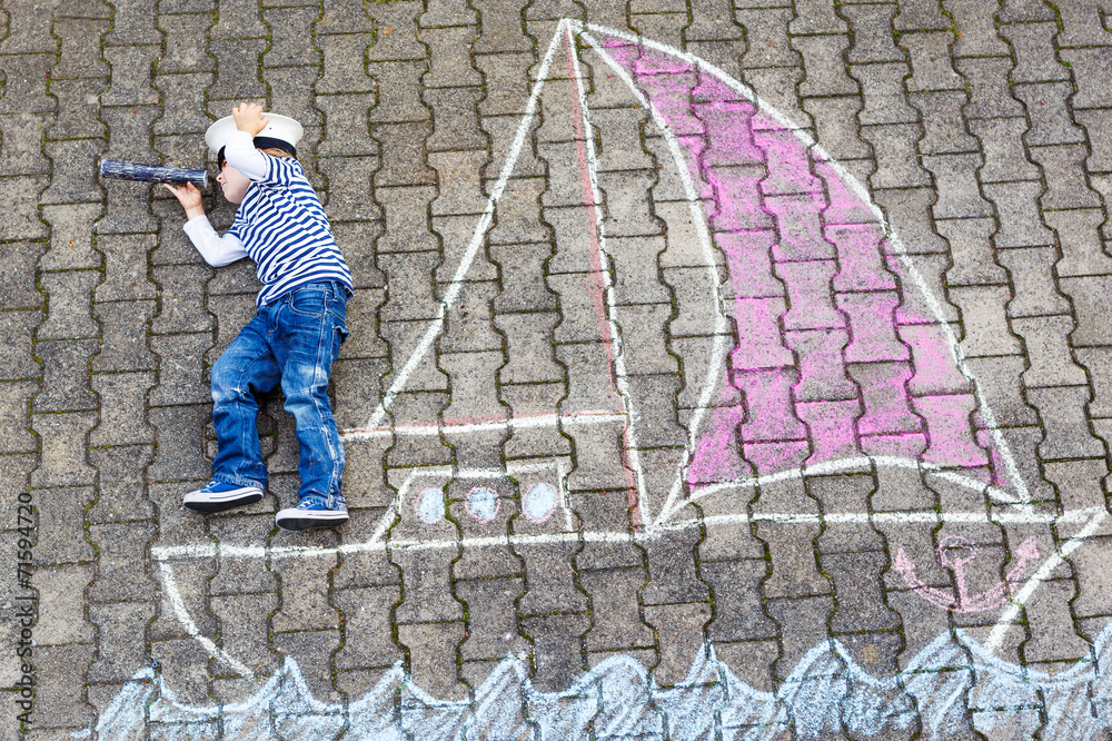 Little boy having fun with ship picture drawing with chalk Little boy having fun with ship picture drawing with chalk