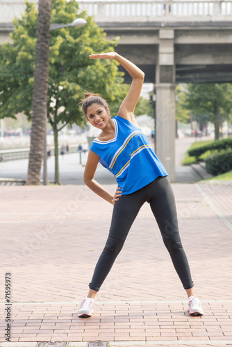 Athletic woman training and exercising in the street, healthy li