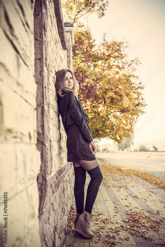 Young pretty elegant lady posing near urban light wall at vintag Young pretty elegant lady posing near urban light wall at vintag