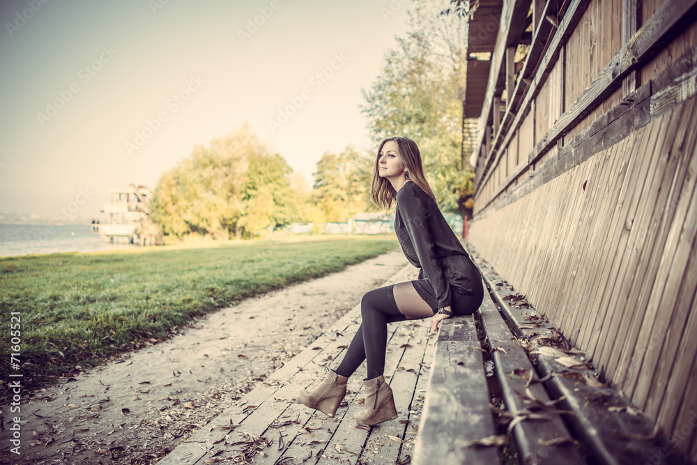 Young pretty girl sitting on bench in park