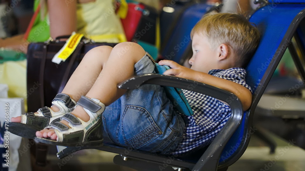 Boy amuse himself with pad in waiting room Boy amuse himself with pad in waiting room