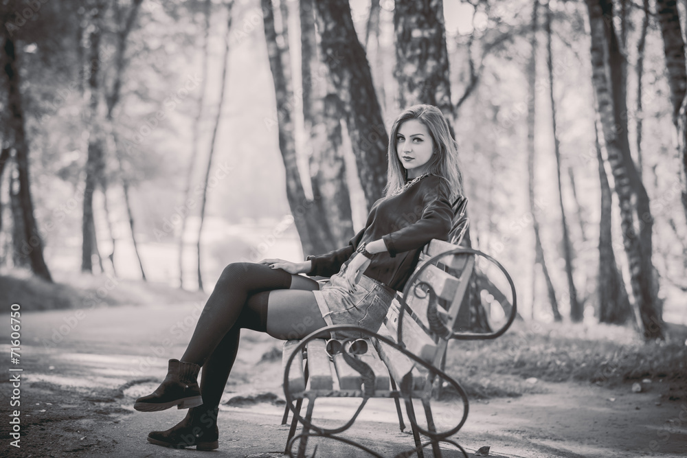Young pretty girl sitting on bench in park Young pretty girl sitting on bench in park