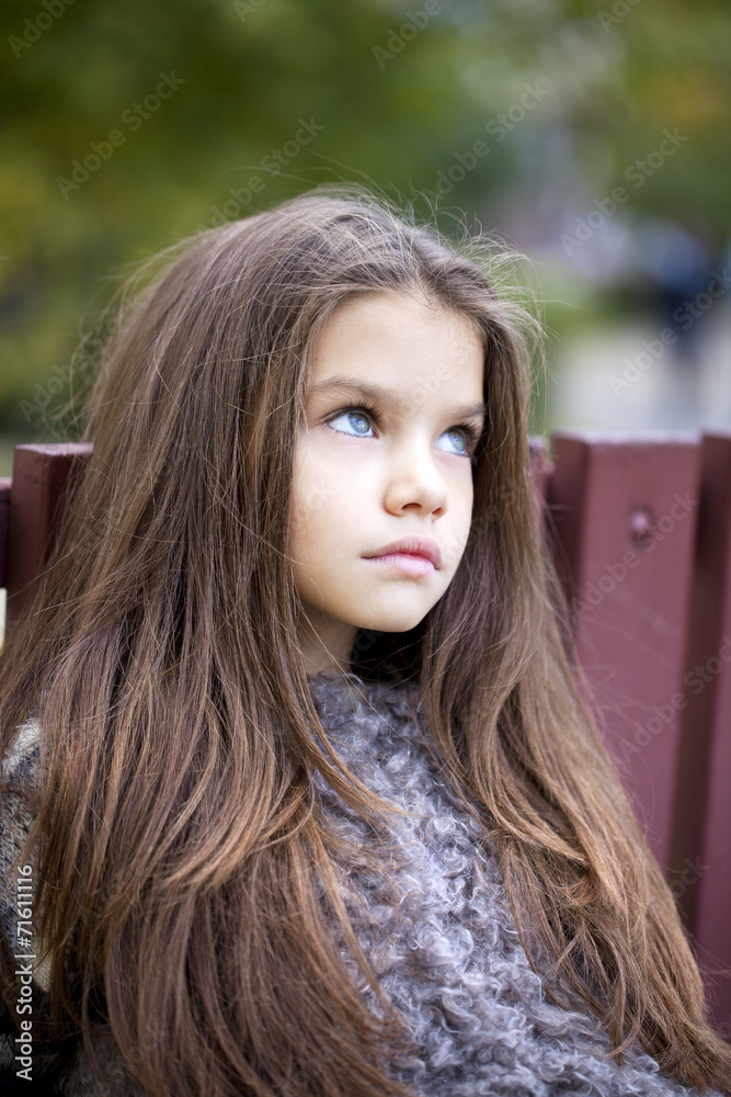Naklejka premium Beautifal little girl in the autumn park