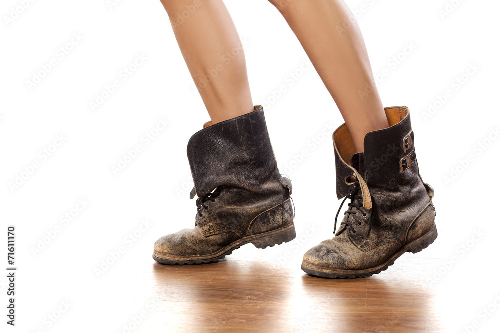 Pretty female legs in muddy military boots
