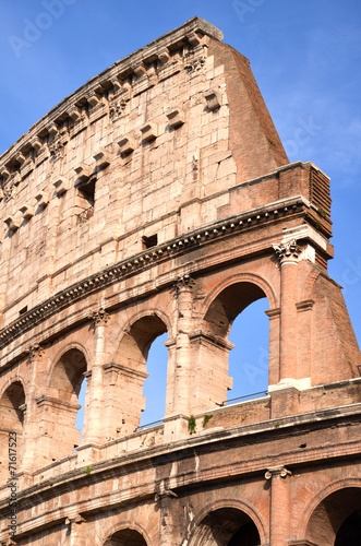 Majestatyczne coloseum w Rzymie na tle niebieskiego nieba, Włoch #71617523