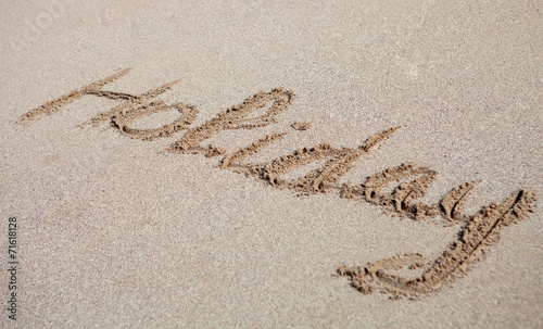 Holiday written on the sand