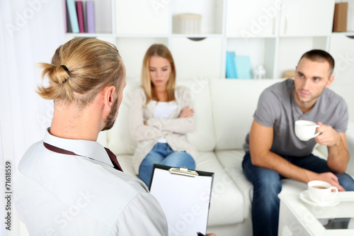 Unhappy couple not talking on couch at therapy session