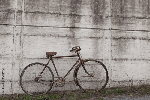 Antique or retro oxidized bicycle outside on a concrete wall