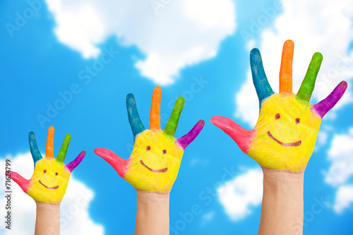 Smiling family hands on a sky background.