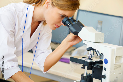 Woman working with a microscope.