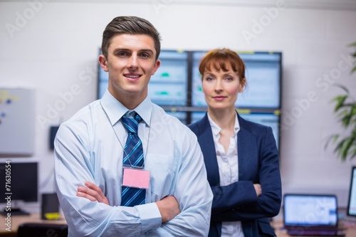 Smiling technicians standing at the camera with arms folded