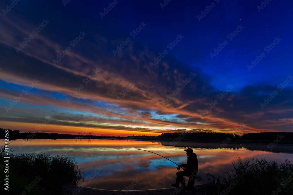 Fisherman fishing rod at dawn on the lake.