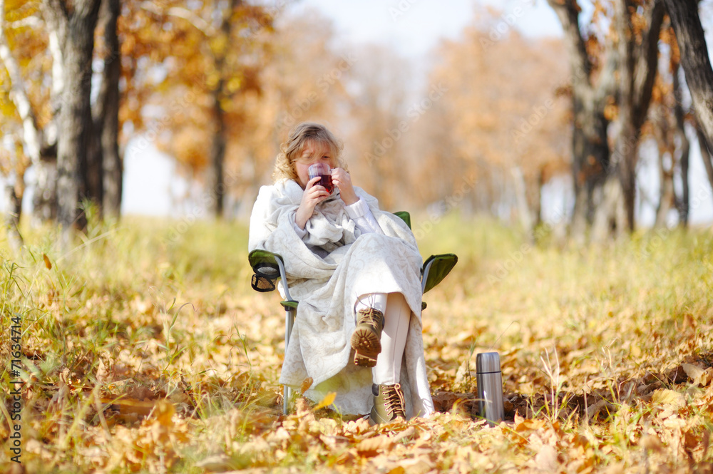 Young woman in autumn, wrapped up against the cold, cool hot tea