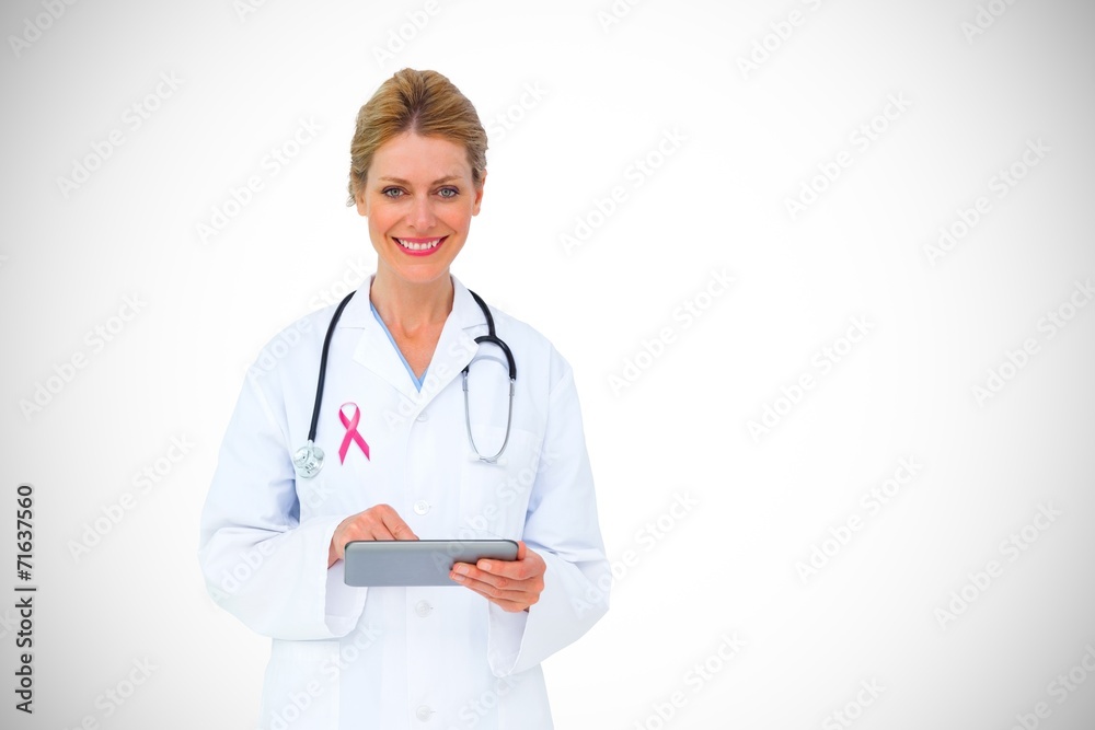 Composite image of blonde doctor using tablet pc Composite image of blonde doctor using tablet pc
