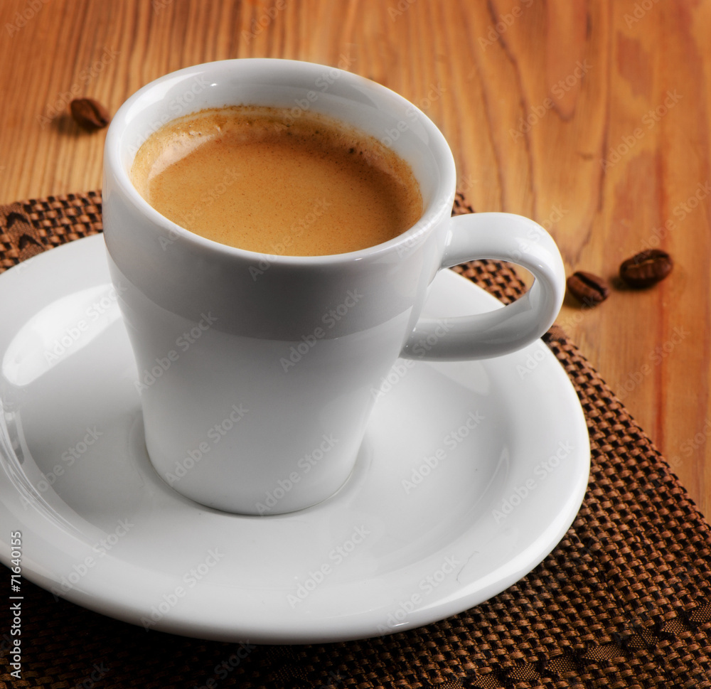 White cup of espresso coffee on wooden table White cup of espresso coffee on wooden table