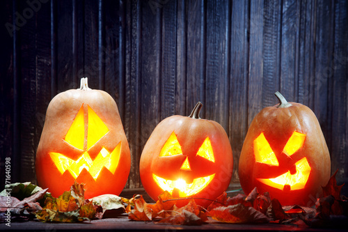 Jack o lanterns  Halloween pumpkin face on wooden background