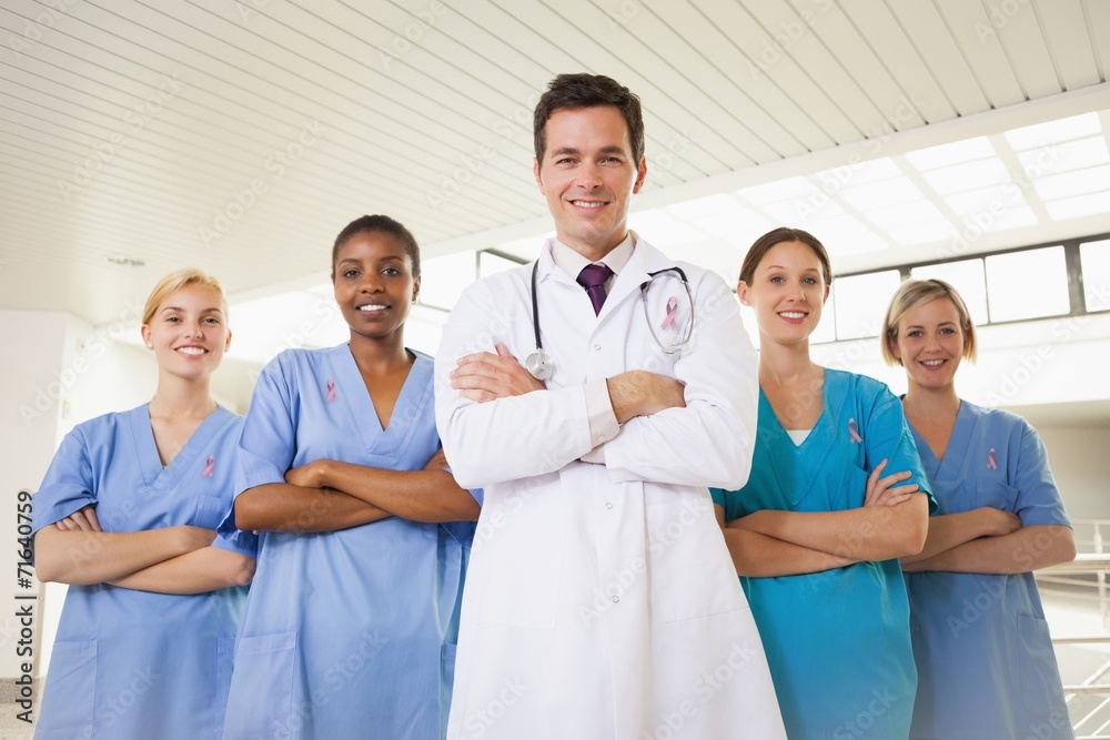 Composite image of smiling doctor and nurses with arms crossed Composite image of smiling doctor and nurses with arms crossed